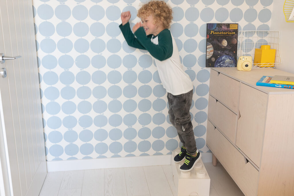chłopiec skacze w pokoju dziecięcym
