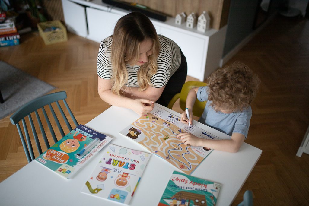 dziecko i mama pracują z książkami dla dzieci z serii „Wiem i ja”