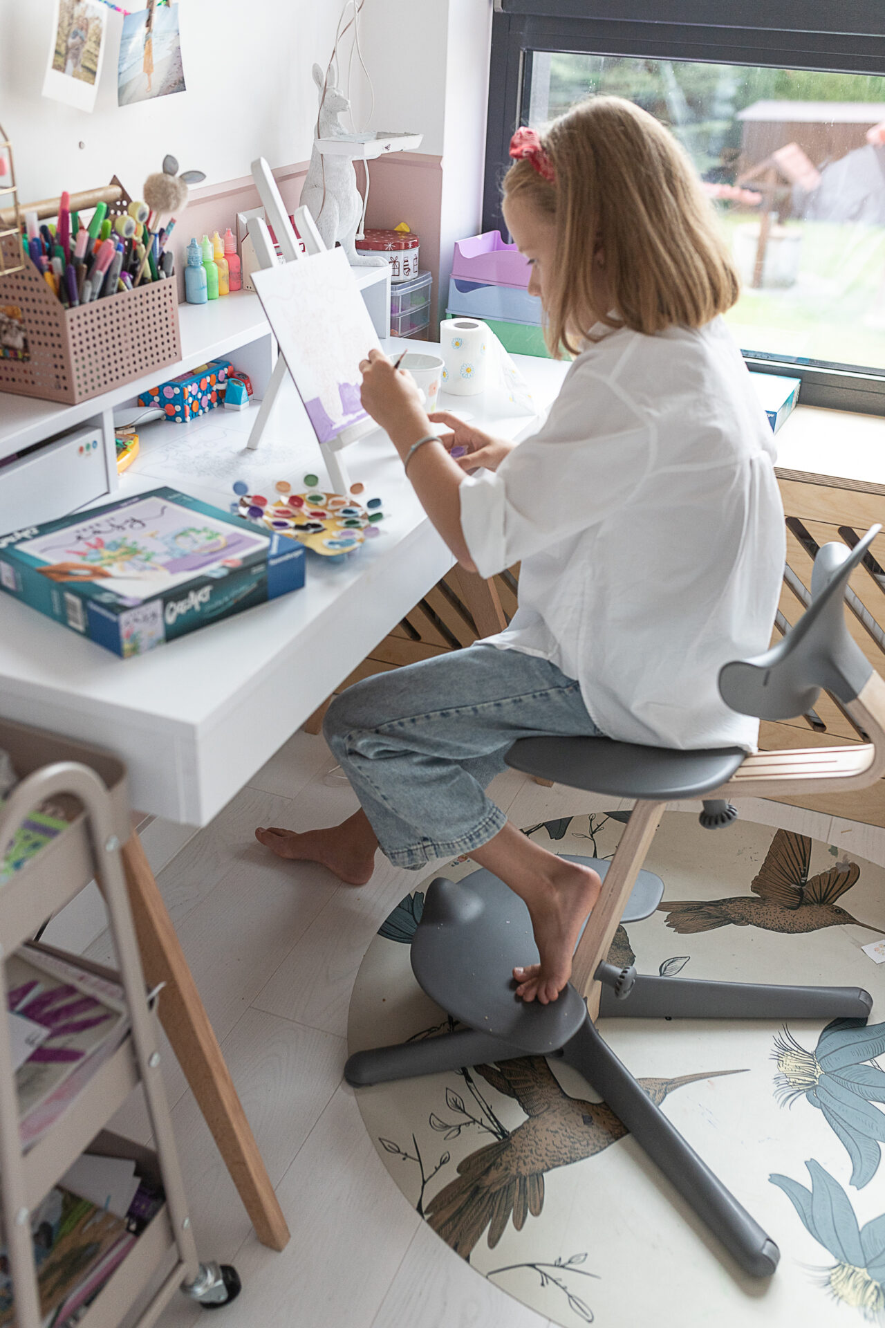 dziewczynka przy biurku maluje creart