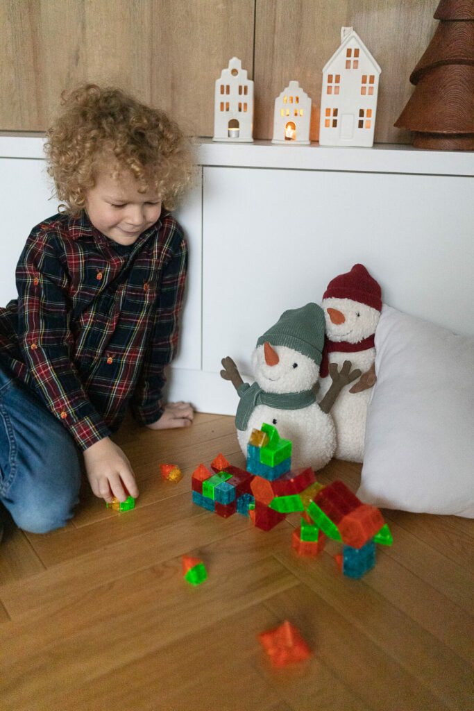 Prezenty na Święta dla dzieci 2022 - chłopiec bawi się Klockami magnetycznymi Magna Tiles Qubix