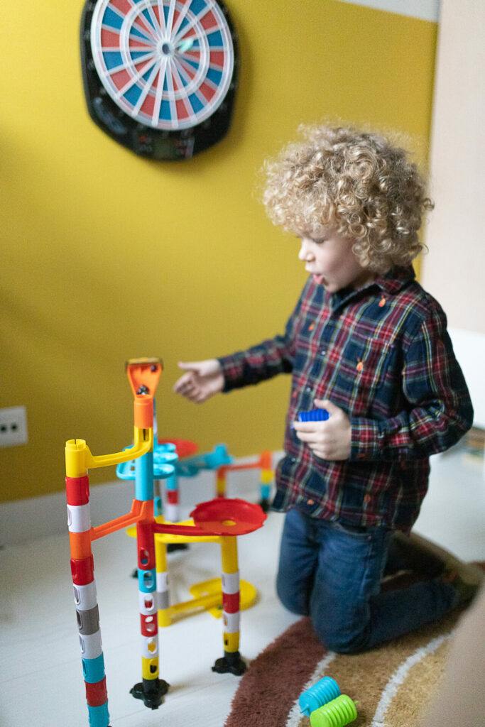 Prezenty na Święta dla dzieci 2022 - chłopiec bawi się zabawką kulodrom Marbles Run