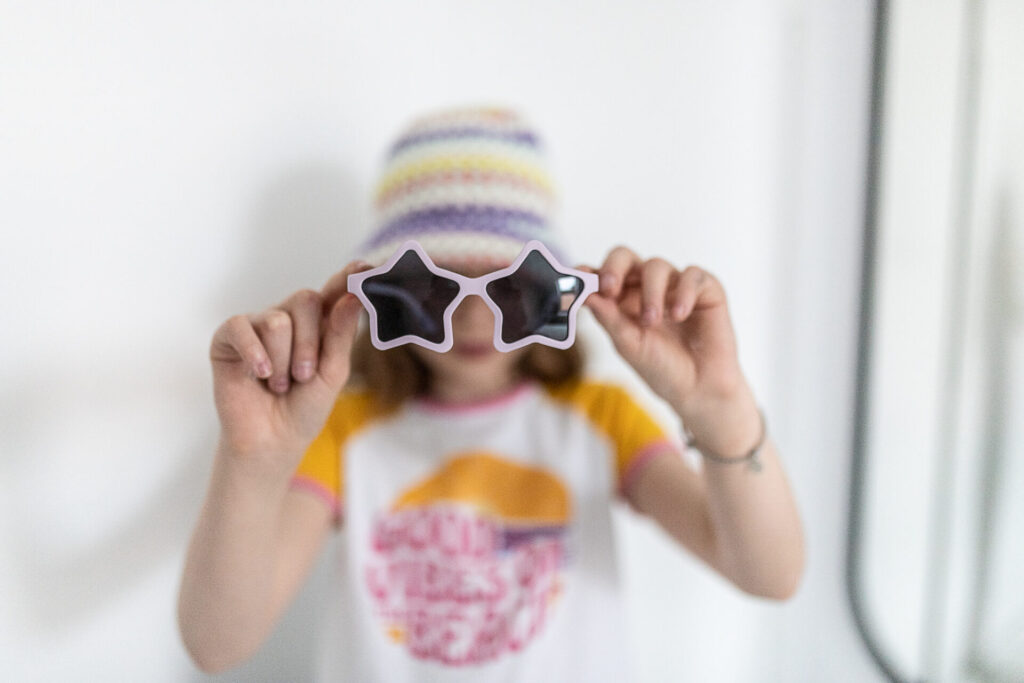dziecko trzyma okulary przeciwsłoneczne dla dzieci w kształcie gwiazdy - real shades Star