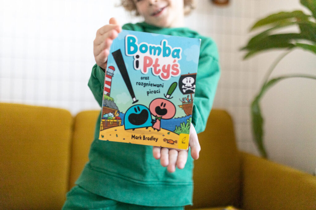 Chłopiec trzyma komiks Bomba i Ptyś 